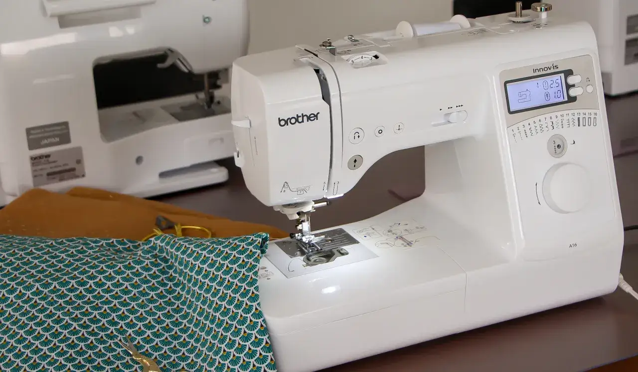 Machine à coudre Brother Innovis prête à l'emploi. Le tissu imprimé et les ciseaux invitent à apprendre comment coudre droit pour des projets parfaits.