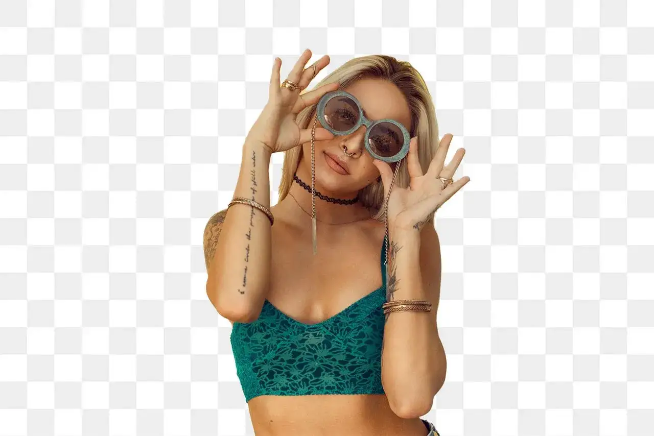 Blondynka z tatuażami i okularami w stylu boho, przygotowująca się do wycinania obrazu.