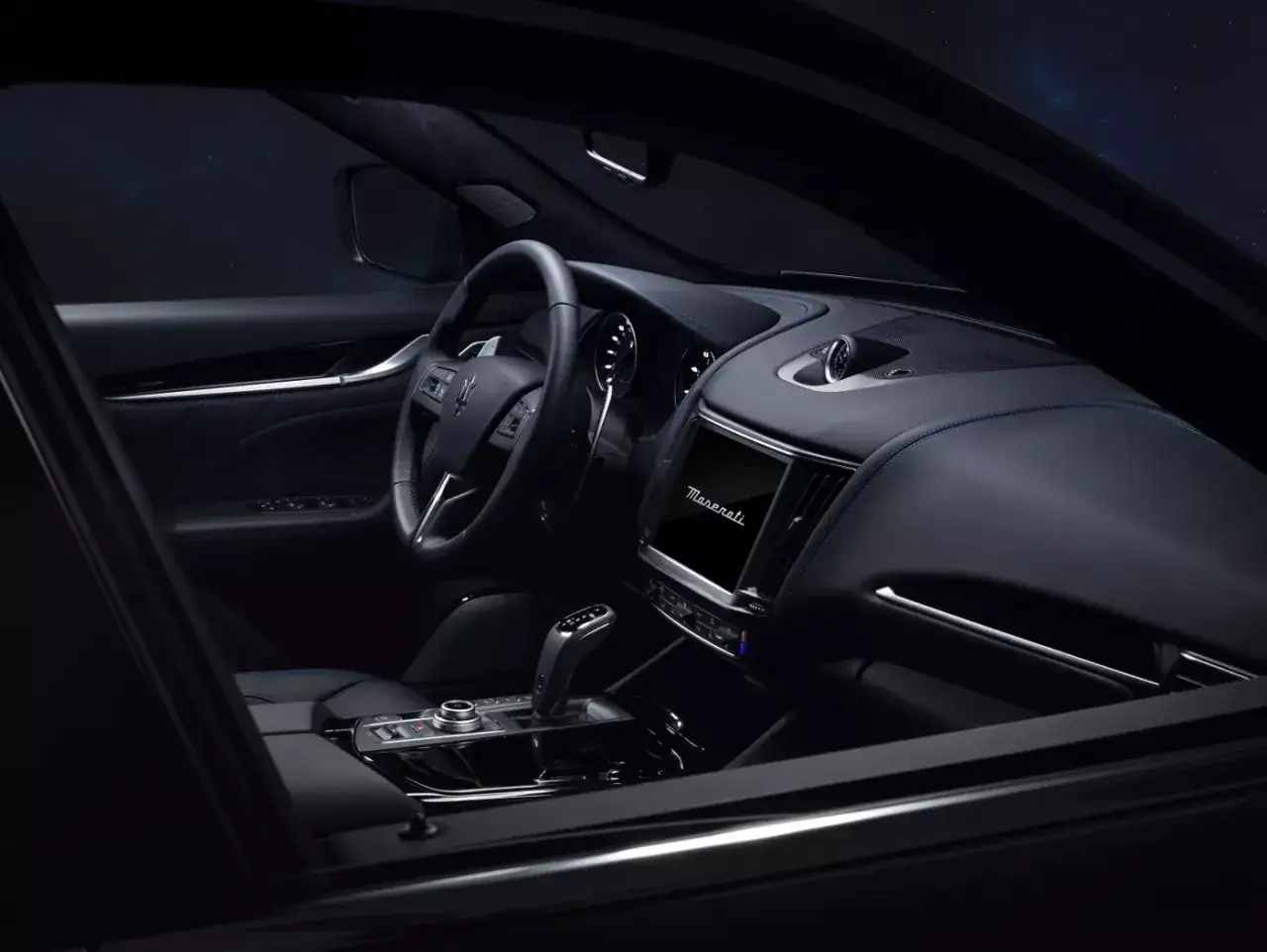 Luksusowe wnętrze Maserati Levante. Elegancka skóra, niebieskie przeszycia i nowoczesny ekran. Sprawdź Maserati Levante cena.