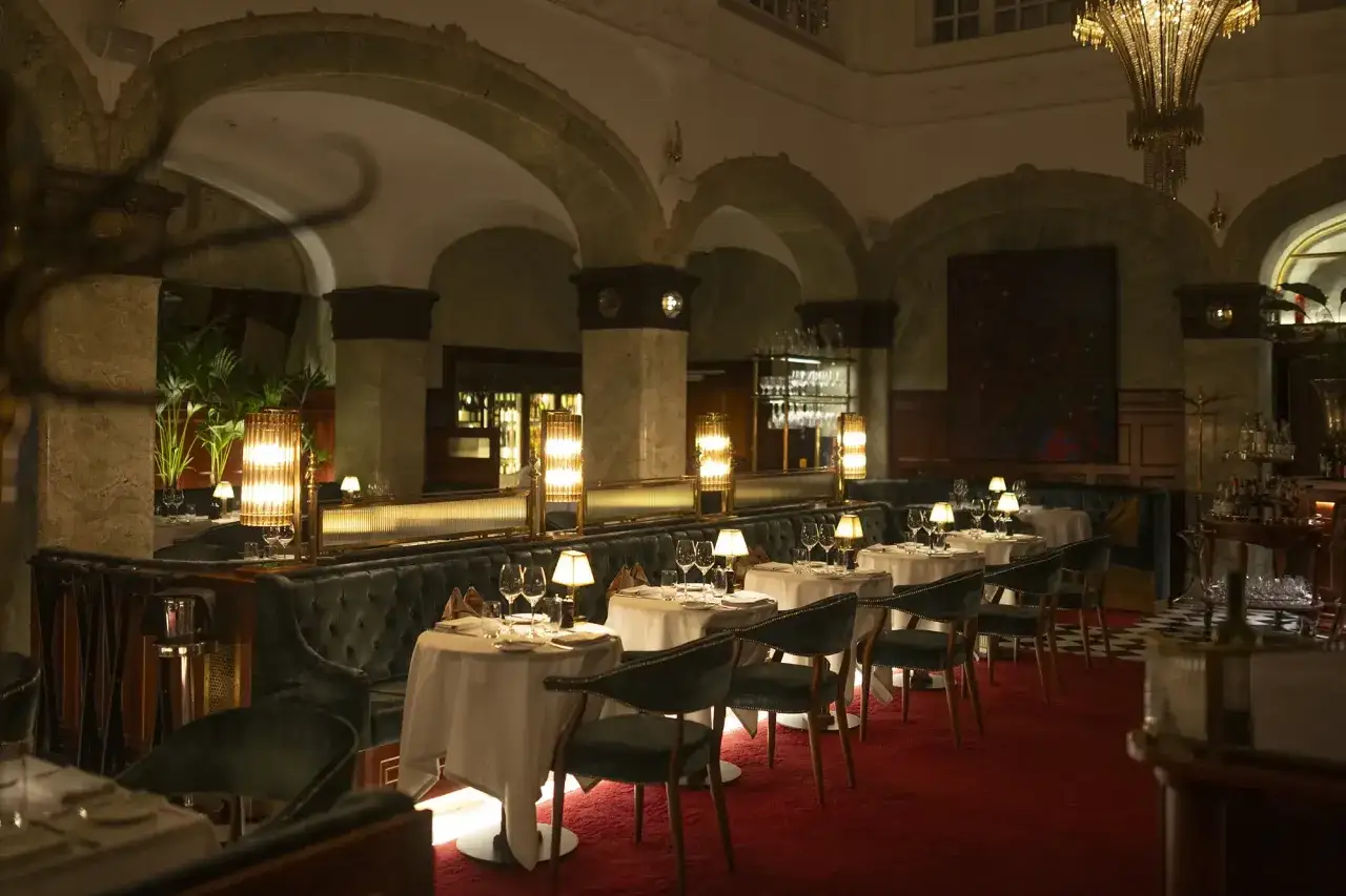 Elegant matsal med sammetssoffor och röda heltäckningsmattor på bonnies bank hotel. Vackra lampor och dukade bord skapar en lyxig atmosfär.