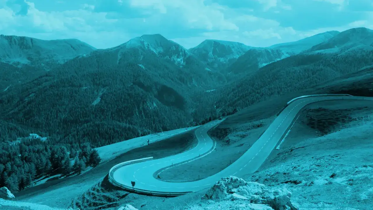Strada tortuosa attraversa montagne boscose in Austria, offrendo viste mozzafiato.