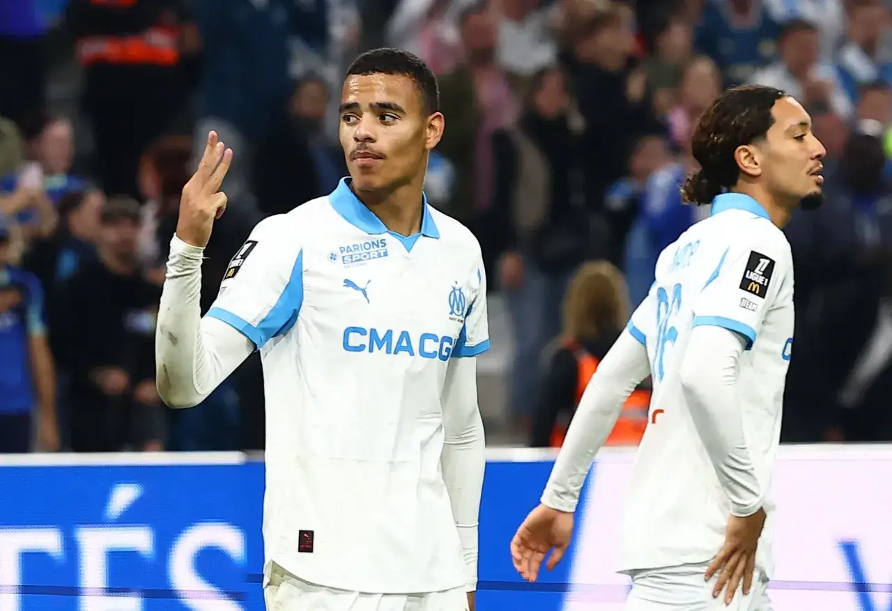 Mason Greenwood celebra un gol con el Marsella, levantando tres dedos en señal de victoria.
