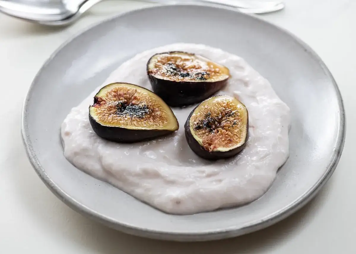 Drei halbierte Feigen auf cremiger Basis, ein k&ouml;stliches Dessert, das an gefrorene Feigen Rezepte erinnert.
