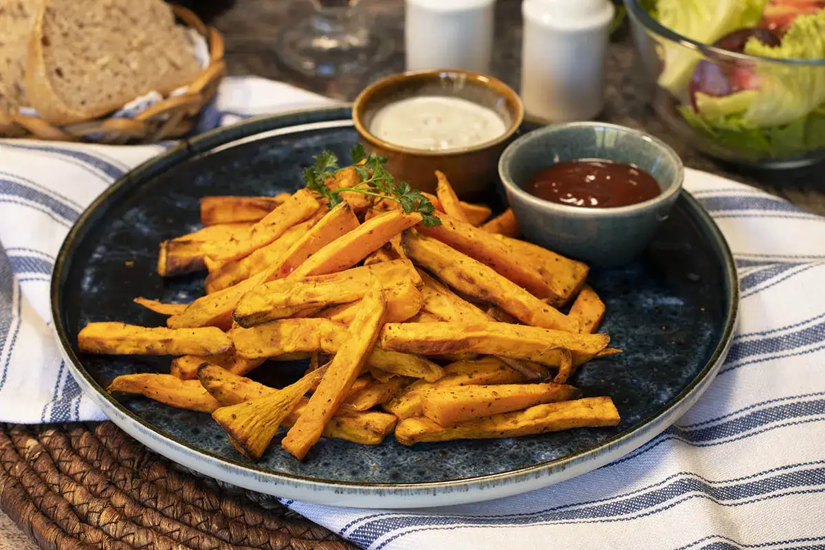 Boniato air fryer crujiente, servido con salsas y pan.