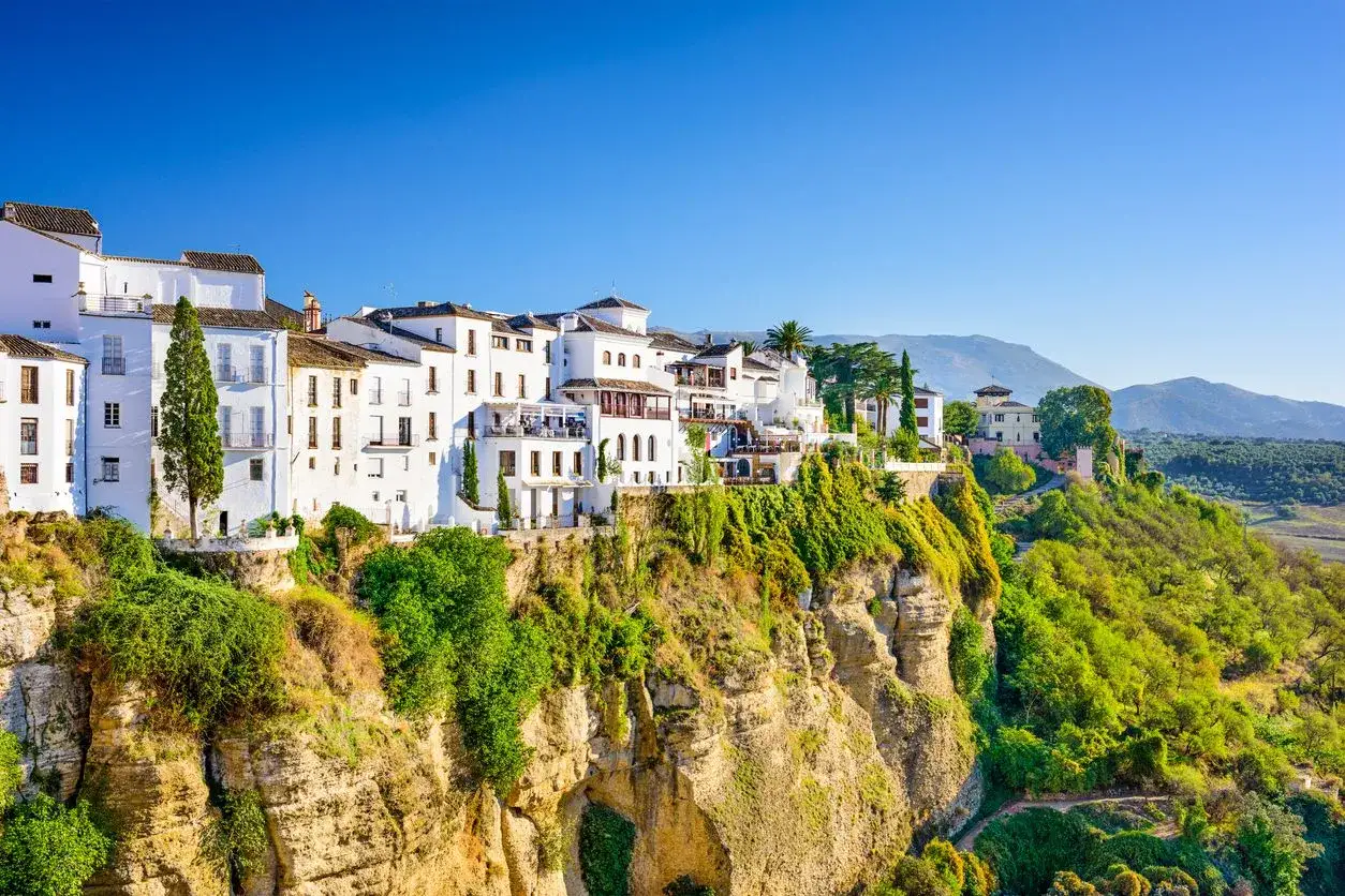 Casas blancas se aferran a un acantilado en Ronda, un destino icónico de la ruta Andalucía.