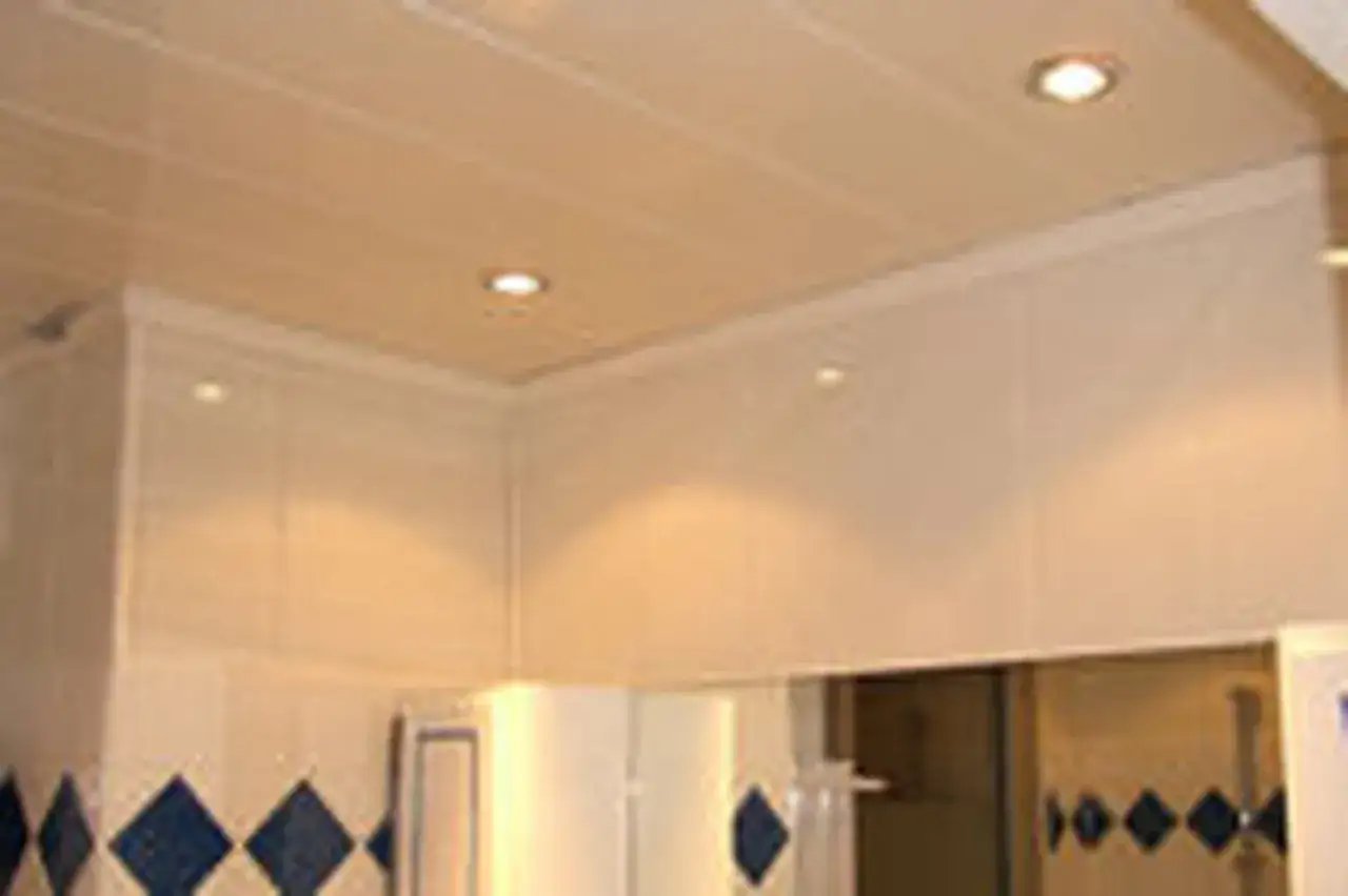 Pose lambris PVC plafond blanc, avec spots int&eacute;gr&eacute;s. Finition moderne et propre pour une pi&egrave;ce lumineuse.