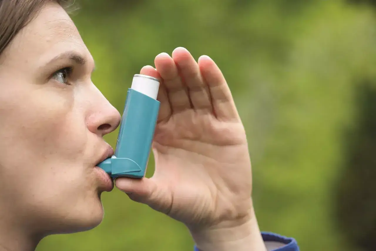 Frau nutzt ein saba Medikament, einen Inhalator, um Atemnot zu lindern.