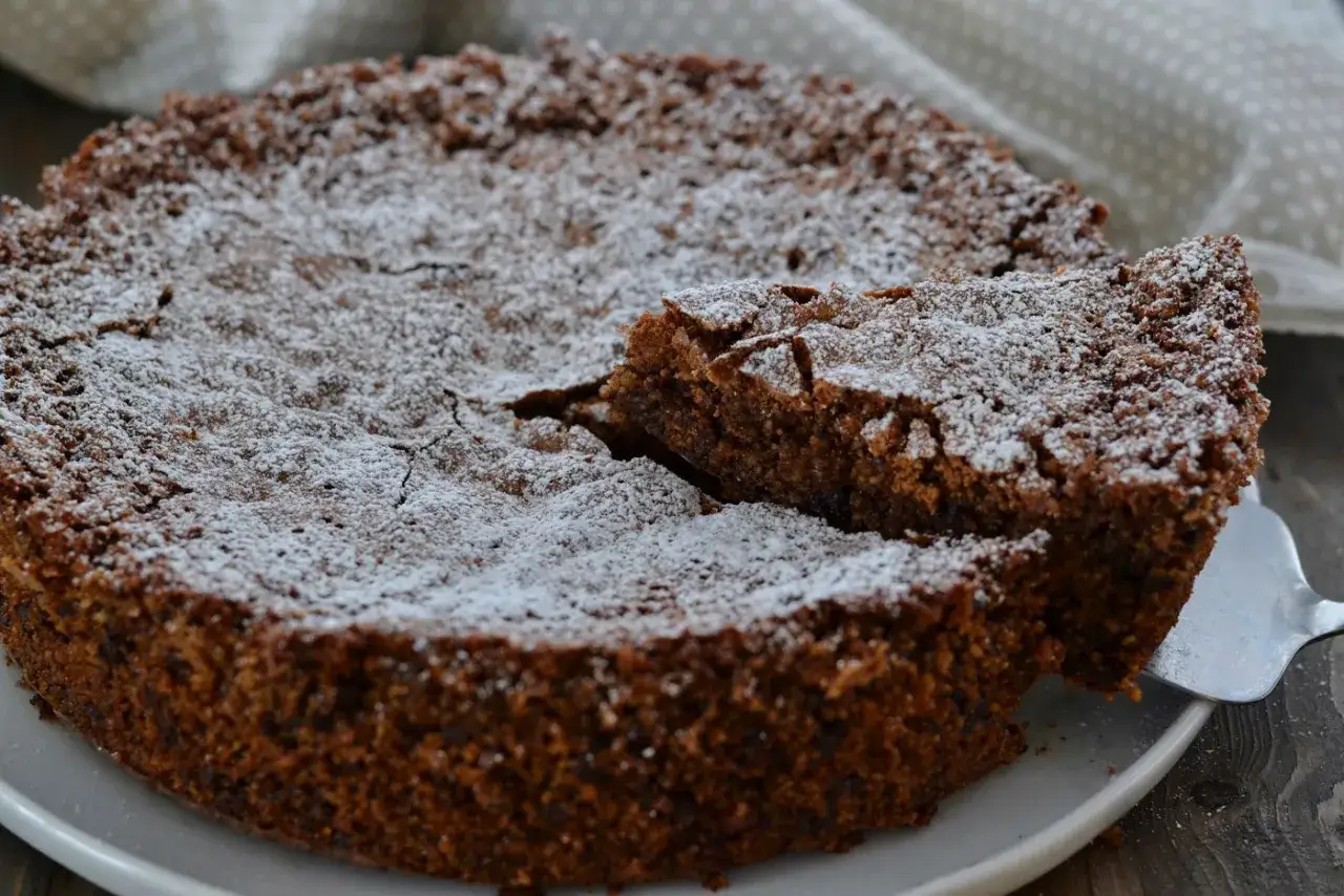 Una deliziosa torta di pane al cioccolato, cosparsa di zucchero a velo, con una fetta appena tagliata.