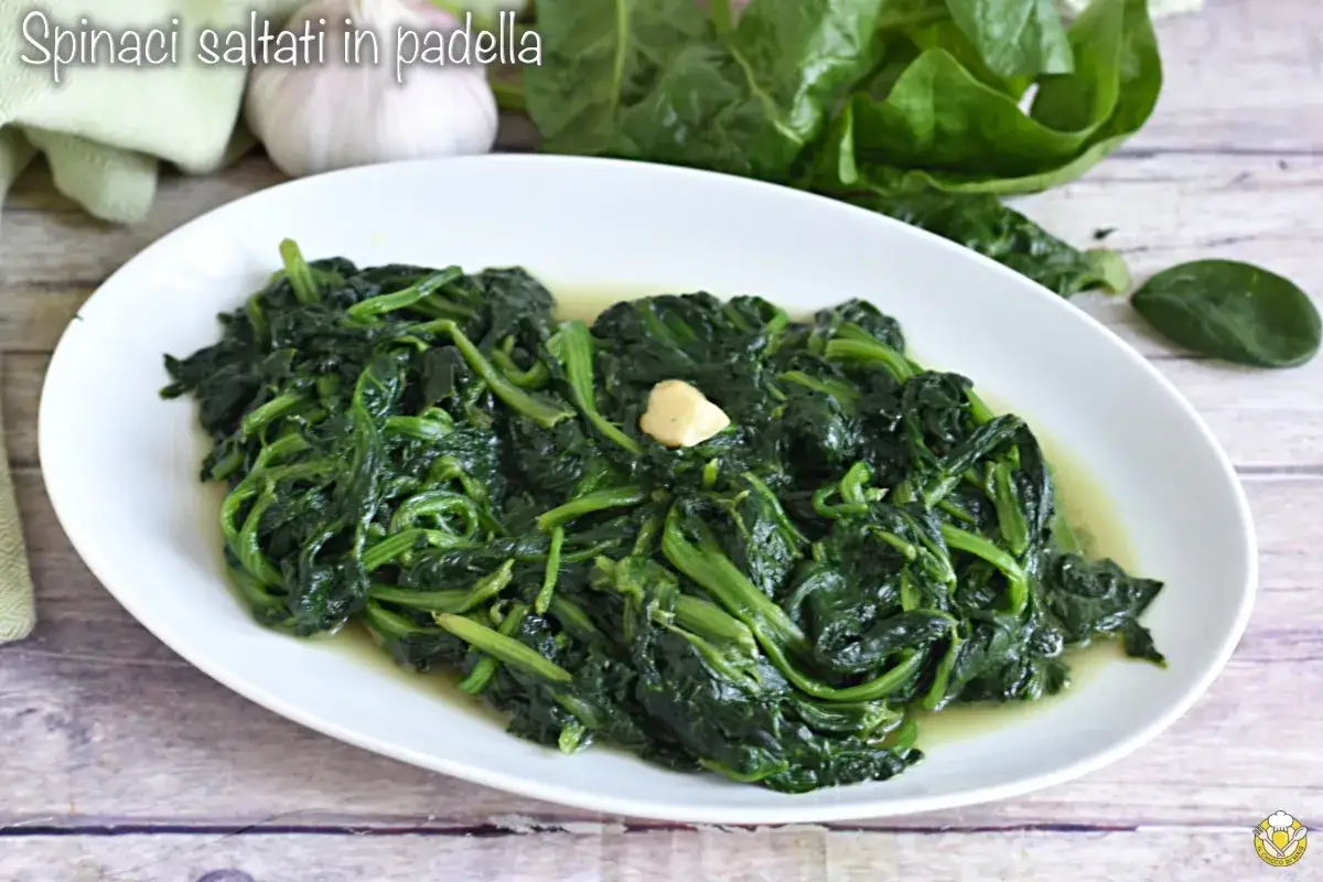 Spinaci saltati in padella, un contorno semplice e gustoso, con un spicchio d'aglio al centro.