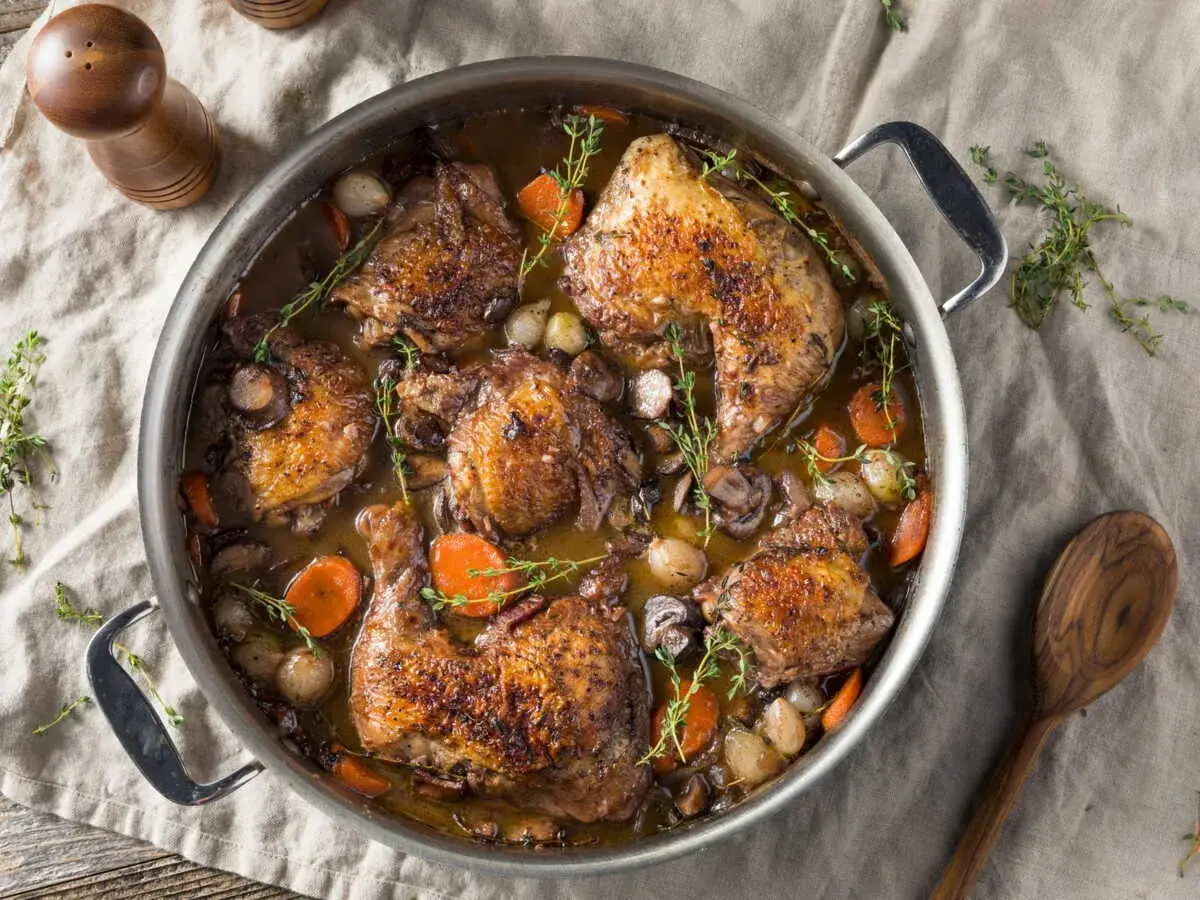 Un plat mijot&eacute; de poulet r&ocirc;ti avec des carottes, des oignons et des champignons, parfait pour des recettes avec poulet r&eacute;confortantes.