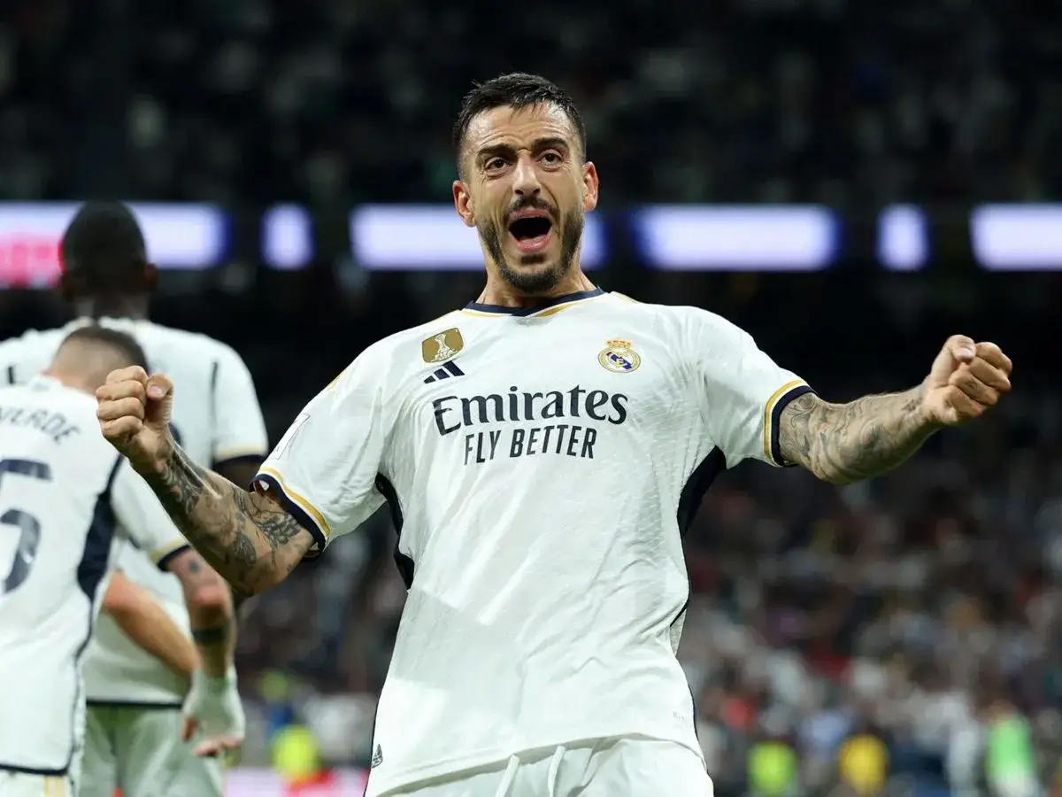 Joselu Mato celebra un gol con el Real Madrid, con los brazos en alto y la boca abierta de emoci&oacute;n.