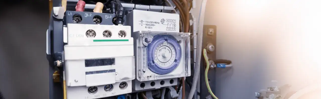 Szczegółowe zdjęcie panelu elektrycznego z widocznym programatorem czasowym. Dowiedz się, jak ustawić programator czasowy, aby zautomatyzować swoje urządzenia.