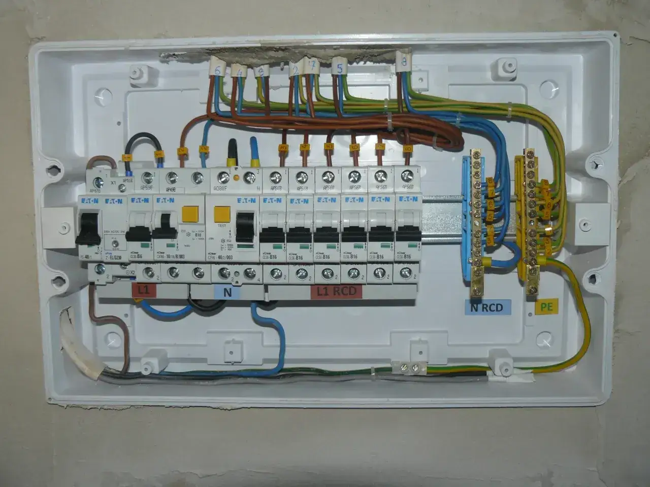 Instalacja elektryczna z bezpiecznikami B16. Widoczne przewody fazowe, neutralne i ochronne. Jak podłączyć bezpiecznik B16?