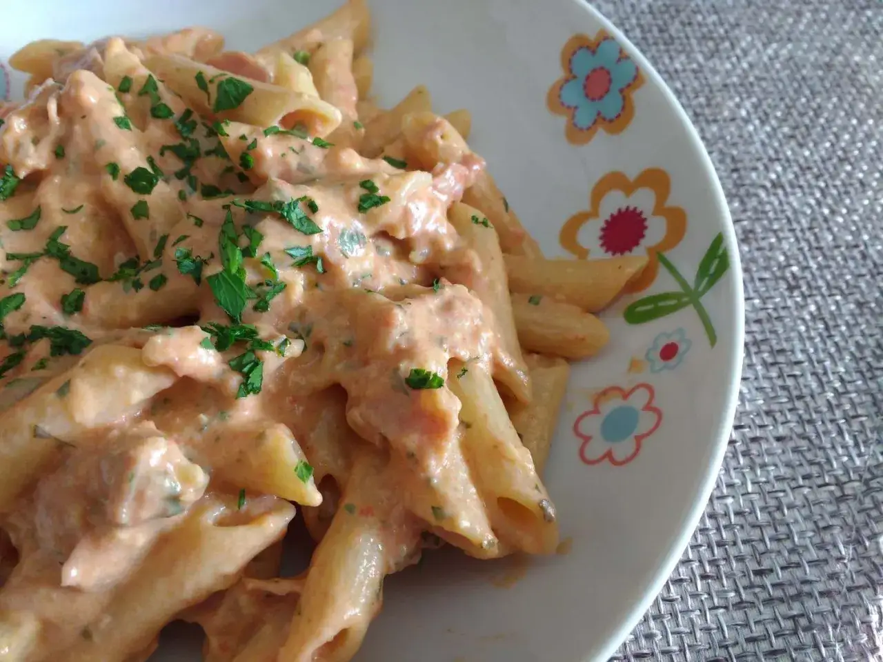 Penne cremose con un sugo rosato e prezzemolo fresco. La panna da cucina rende il tutto irresistibile.