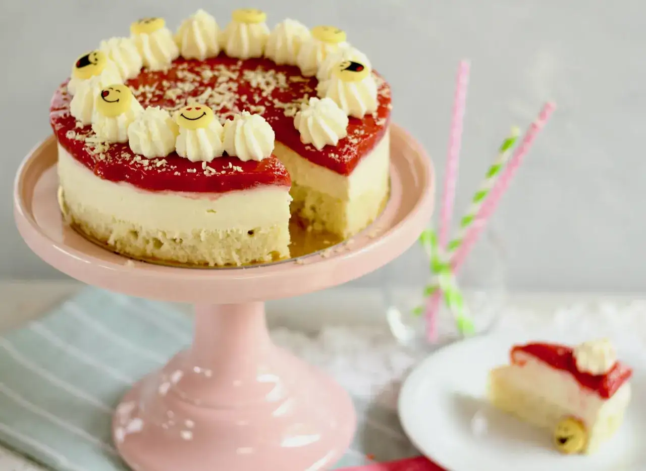 Ein köstlicher Kuchen, der wie Spaghetti-Eis aussieht, mit Erdbeer-Topping und lustigen Smiley-Dekorationen.