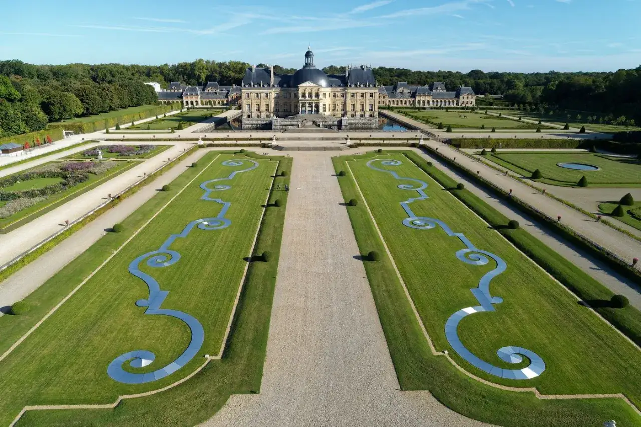 Vue aérienne du château de Vaux-le-Vicomte et de ses jardins à la française, avec leurs parterres symétriques et leurs bassins.