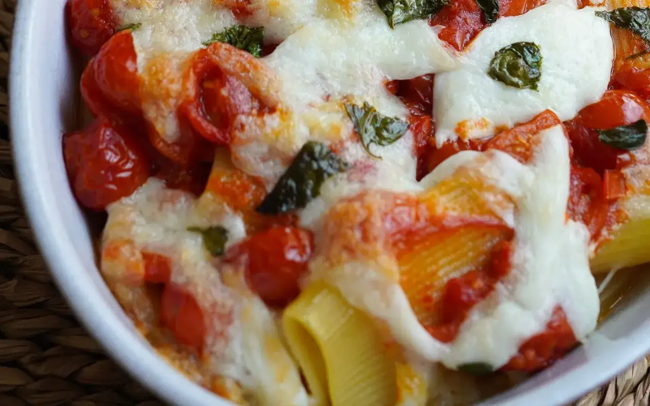 Un primo piatto invitante: pasta alla sorrentina con pomodorini succosi, mozzarella filante e basilico fresco.