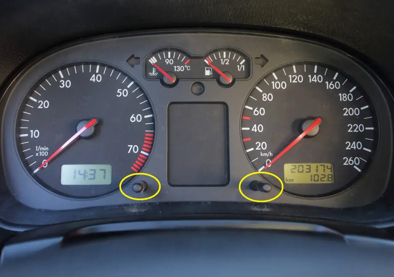 Deska rozdzielcza samochodu z widocznym licznikiem kilometrów (203174 km) i wskaźnikiem paliwa. Dwa przyciski do regulacji podświetlenia.