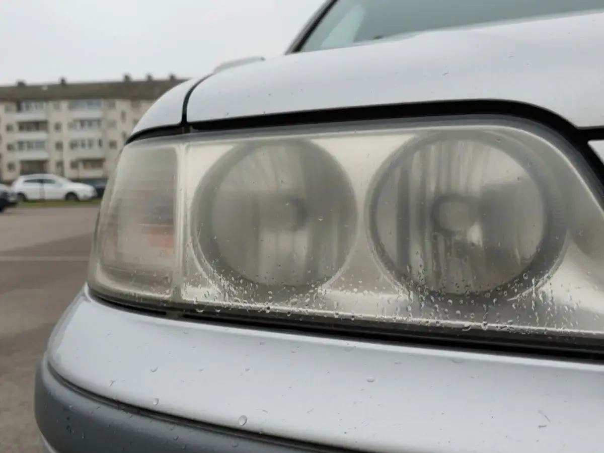 Zmatowione lampy w samochodzie, pokryte kropelkami wody, wyglądają na zmęczone.