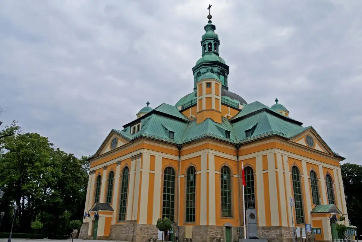 Kościół Pokoju w Świdnicy, jeden z punktów, które warto zobaczyć w okolicy Jeleniej Góry, z charakterystyczną żółto-białą fasadą i zielonym dachem.