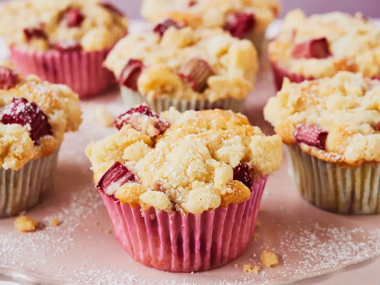 Saftige Rhabarber Muffins mit Streuseln, best&auml;ubt mit Puderzucker, warten auf den Genuss.