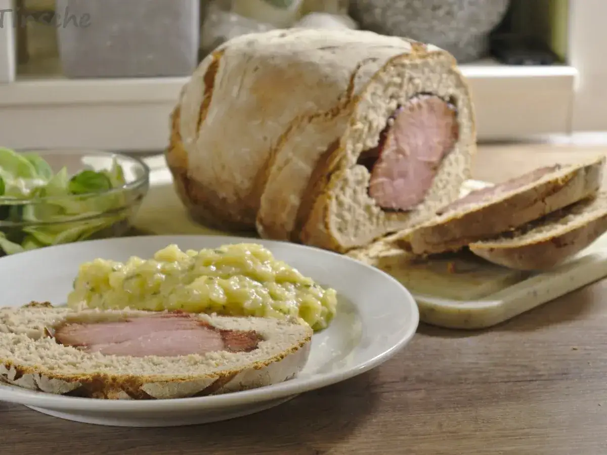 Schinken im Brotteig mit Kartoffelsalat und Salat als Beilagen. Ein herzhaftes Gericht, das zum Genießen einlädt.