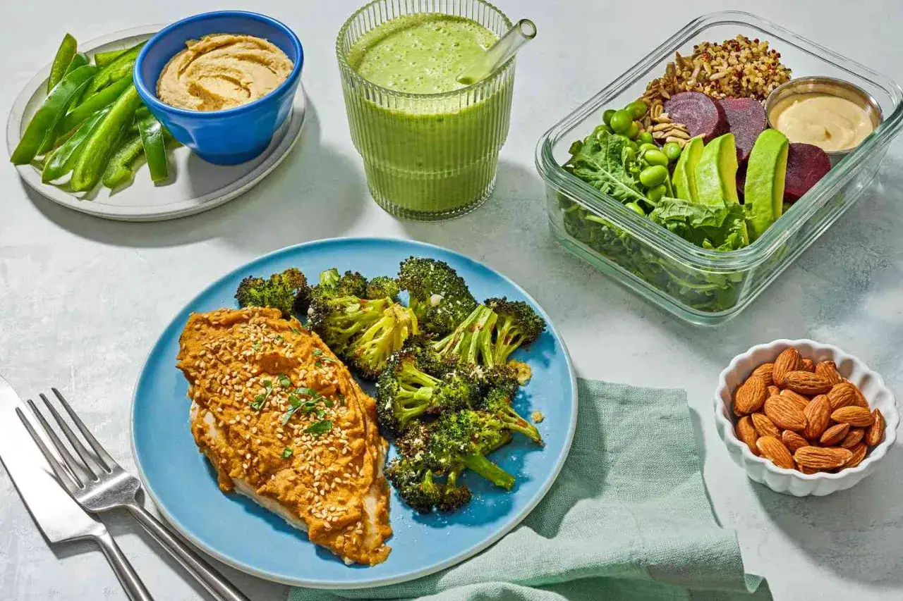 Un plan nutricional semanal saludable: pollo con br&oacute;coli, ensalada en tupper, hummus con pimientos, batido verde y almendras.