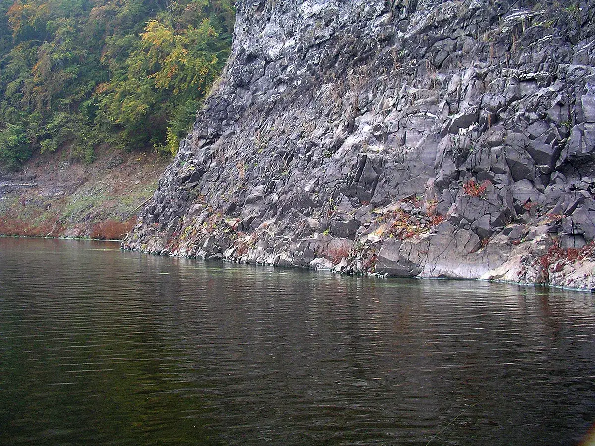Ruhige Wasserfl&auml;che der Bleilochtalsperre mit steiler Felswand und bewaldetem Hang. Perfekt f&uuml;r Angler, die hier ihr Gl&uuml;ck versuchen.
