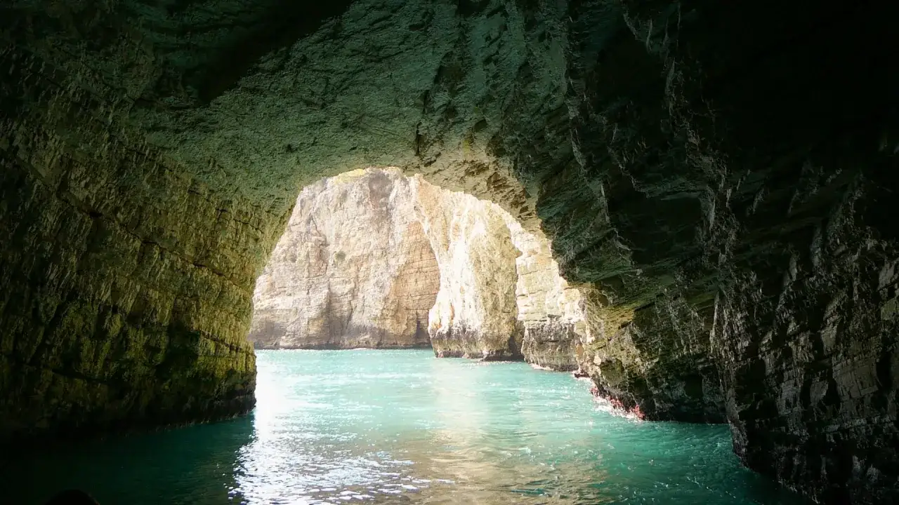 Grotta marina con acqua turchese e rocce imponenti. Un'esplorazione di Vieste cosa vedere, tra grotte e mare cristallino.
