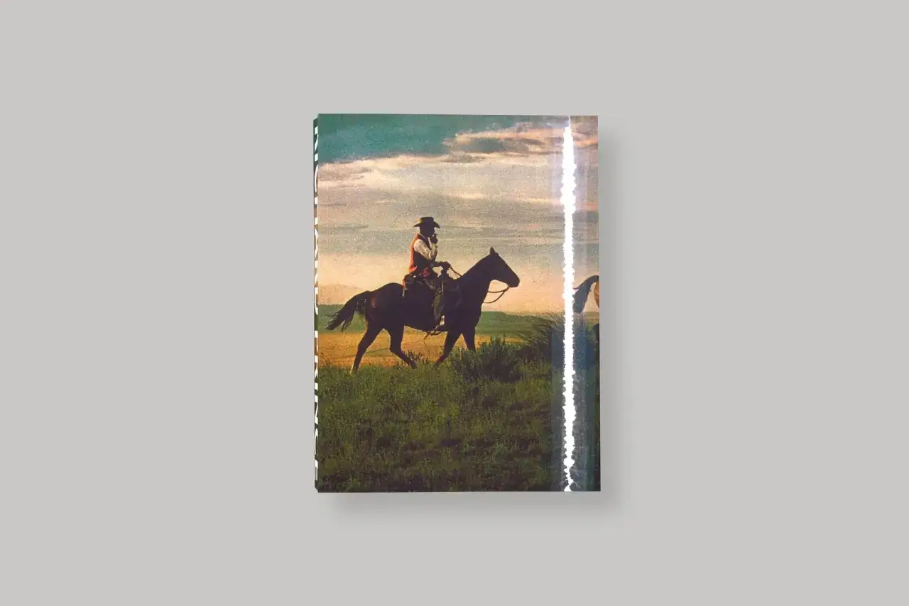 Un cow-boy sur son cheval, une &oelig;uvre de Richard Prince, traverse un champ verdoyant sous un ciel nuageux.