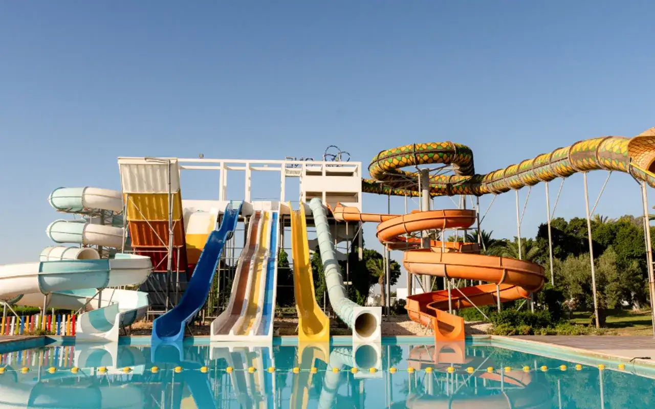 Kolorowe zjeżdżalnie wodne w aquaparku przy plaży Sahary, gotowe na letnie szaleństwo.