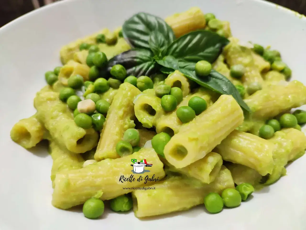 Un piatto cremoso di pasta e piselli, guarnito con basilico fresco. Un classico confortante, pronto per essere gustato.