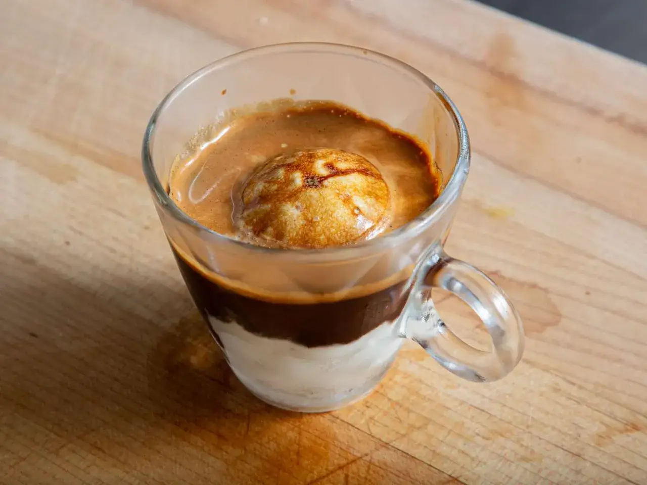 Idealne affogato kawa: gorący espresso zalany na zimne lody waniliowe w szklance.