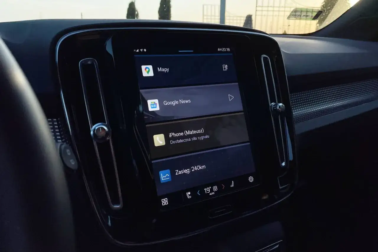 Ekran Volvo z Android Auto, wyświetlający mapy, Google News i powiadomienie z iPhone'a.
