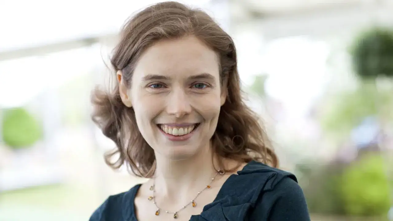 Porträt von Madeline Miller, lächelnd, mit braunen Haaren und einem Collier.