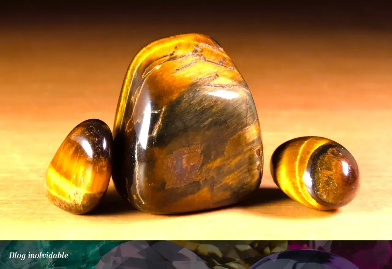 Tres piedras pulidas de ojo de tigre, una gema marrón con vetas doradas, brillan sobre una superficie de madera.