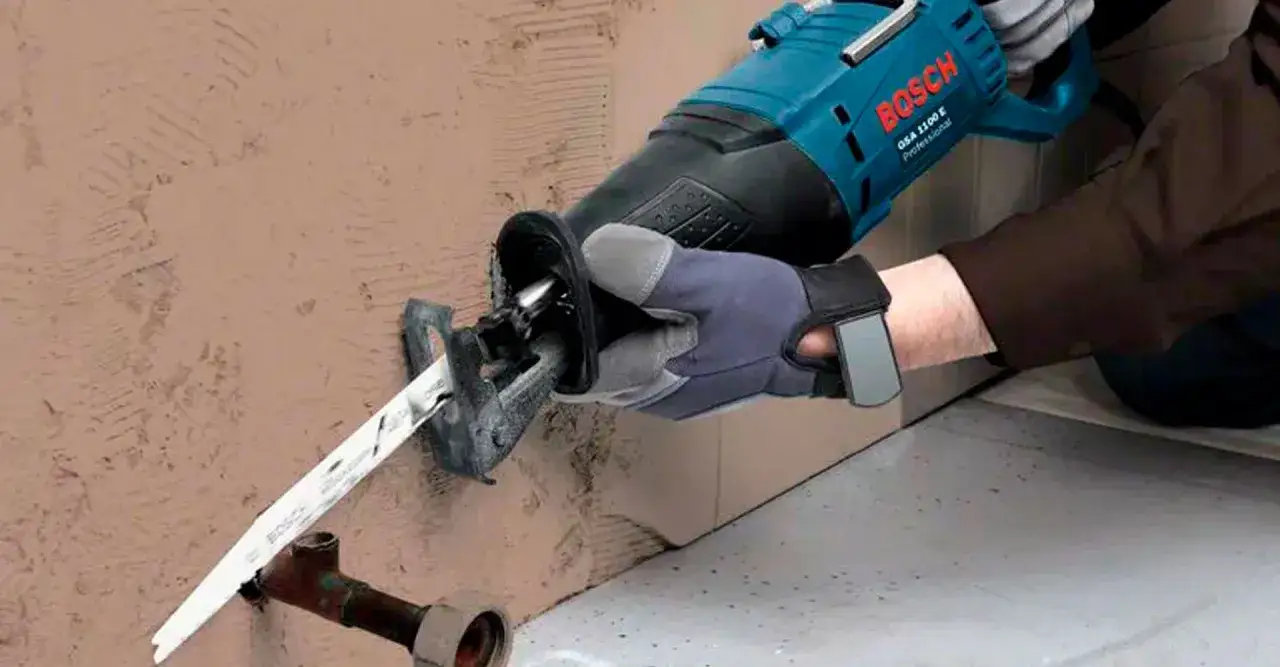 Un operario usa una sierra sable Bosch para cortar una tubería. Esta herramienta es ideal para trabajos de demolición y corte.