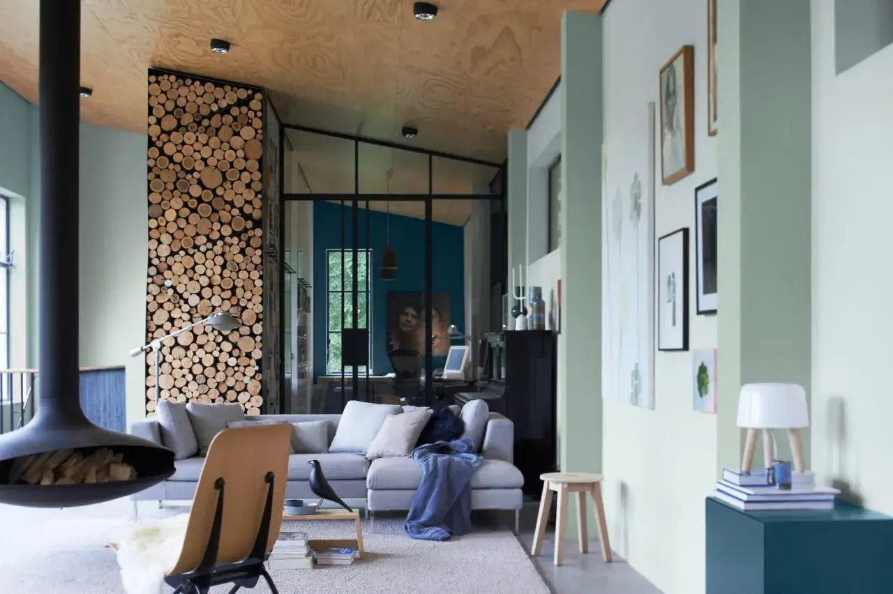 Salon moderne avec mur de bois, canapé gris, cheminée suspendue et plafond en bois. Quelle peinture pour plafond ? Le bois brut est une option.