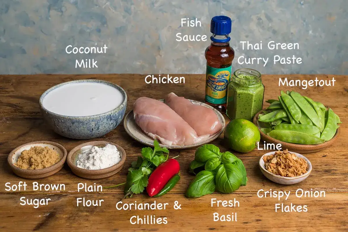 Zutaten f&uuml;r ein Thai Curry: Kokosmilch, H&auml;hnchen, gr&uuml;ne Currypaste, Fischsauce, Zuckerschoten, Limette, brauner Zucker, Mehl, Koriander, Chilis, Basilikum und R&ouml;stzwiebeln.