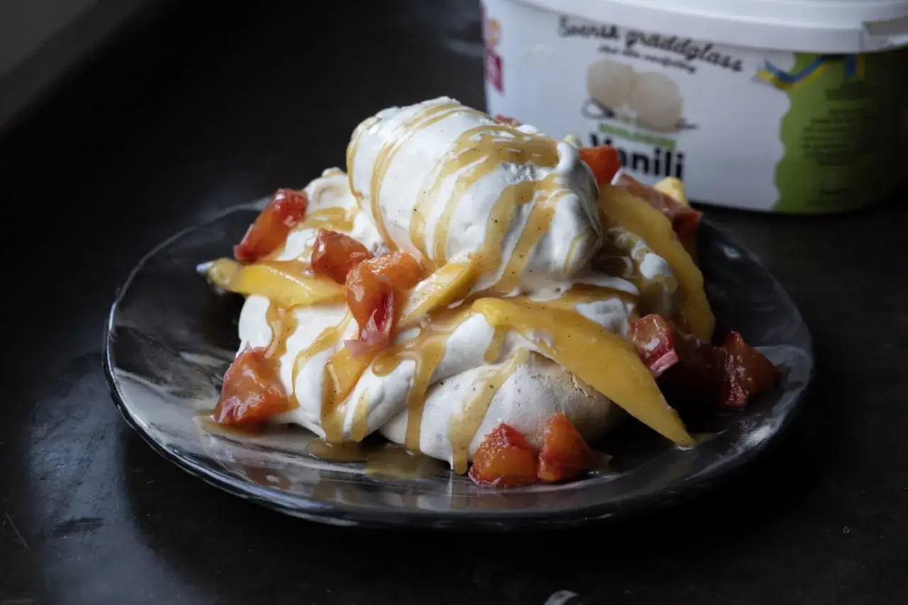 Maräng med vaniljglass, frukt och en härlig kolasås. Ett enkelt recept på kolasås gör desserten komplett.