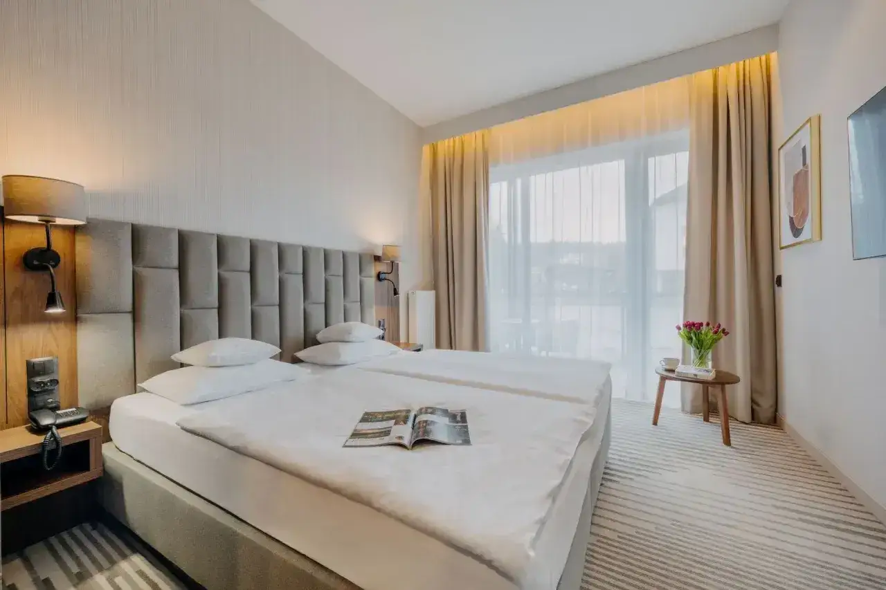 Pokój superior: przestronne łóżka, eleganckie oświetlenie, duży balkon z widokiem. Idealny na relaksujący pobyt.