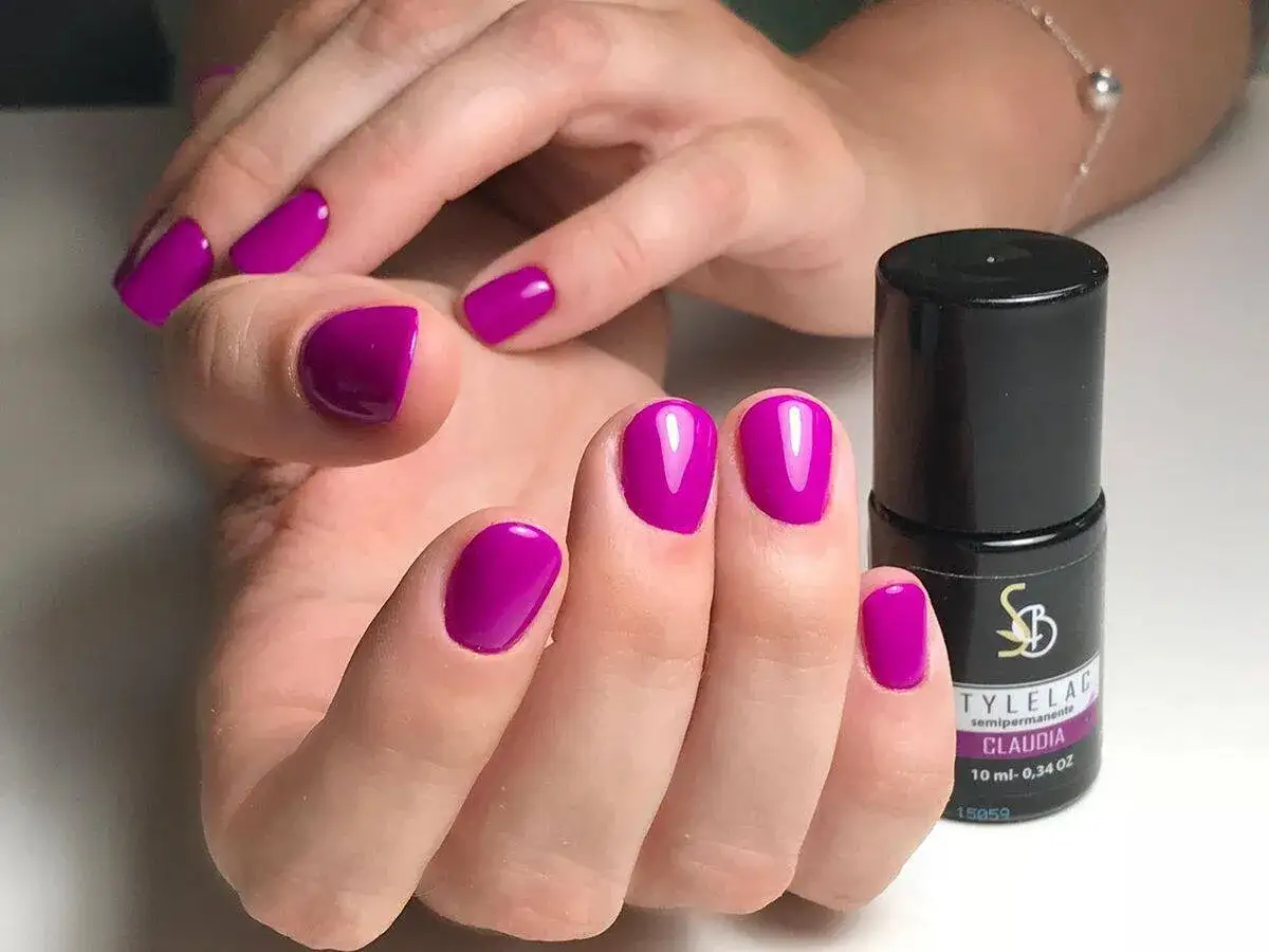 Mani perfette con smalto semipermanente color fucsia intenso. La durata è garantita per un look impeccabile.