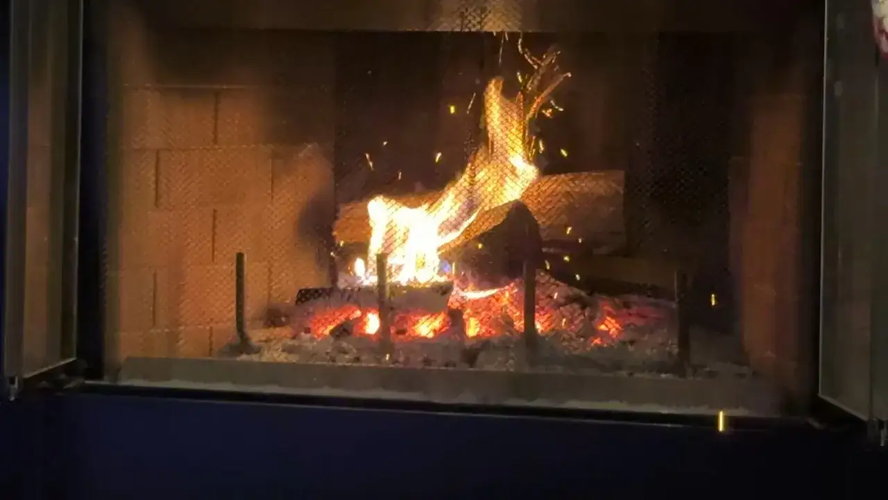 Glühendes Fichtenholz verbrennen im Kamin, Funken fliegen.