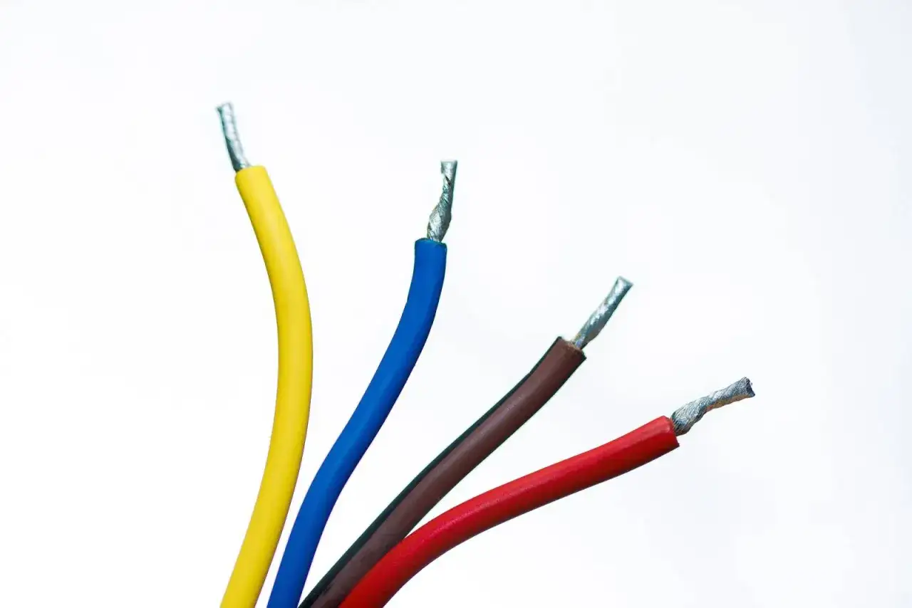 Faisceau de fils électriques colorés : jaune, bleu, fil marron et rouge, prêts pour une connexion.