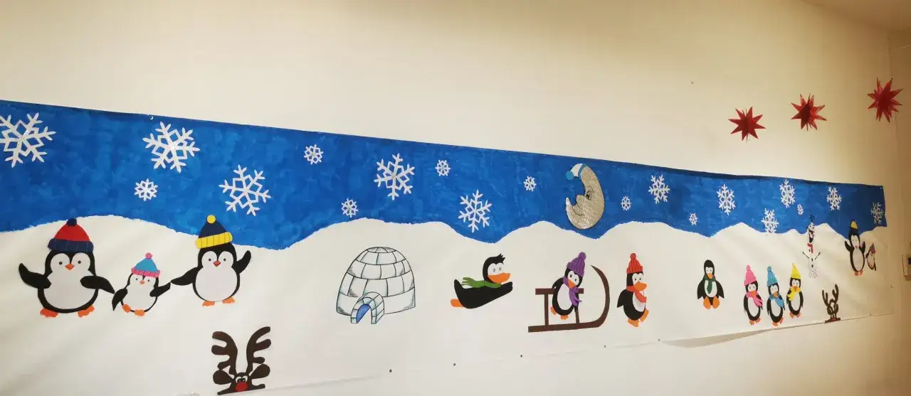 Allegra scena invernale con pinguini, pupazzi di neve e un igloo, perfetta per le decorazioni invernali scuola primaria.