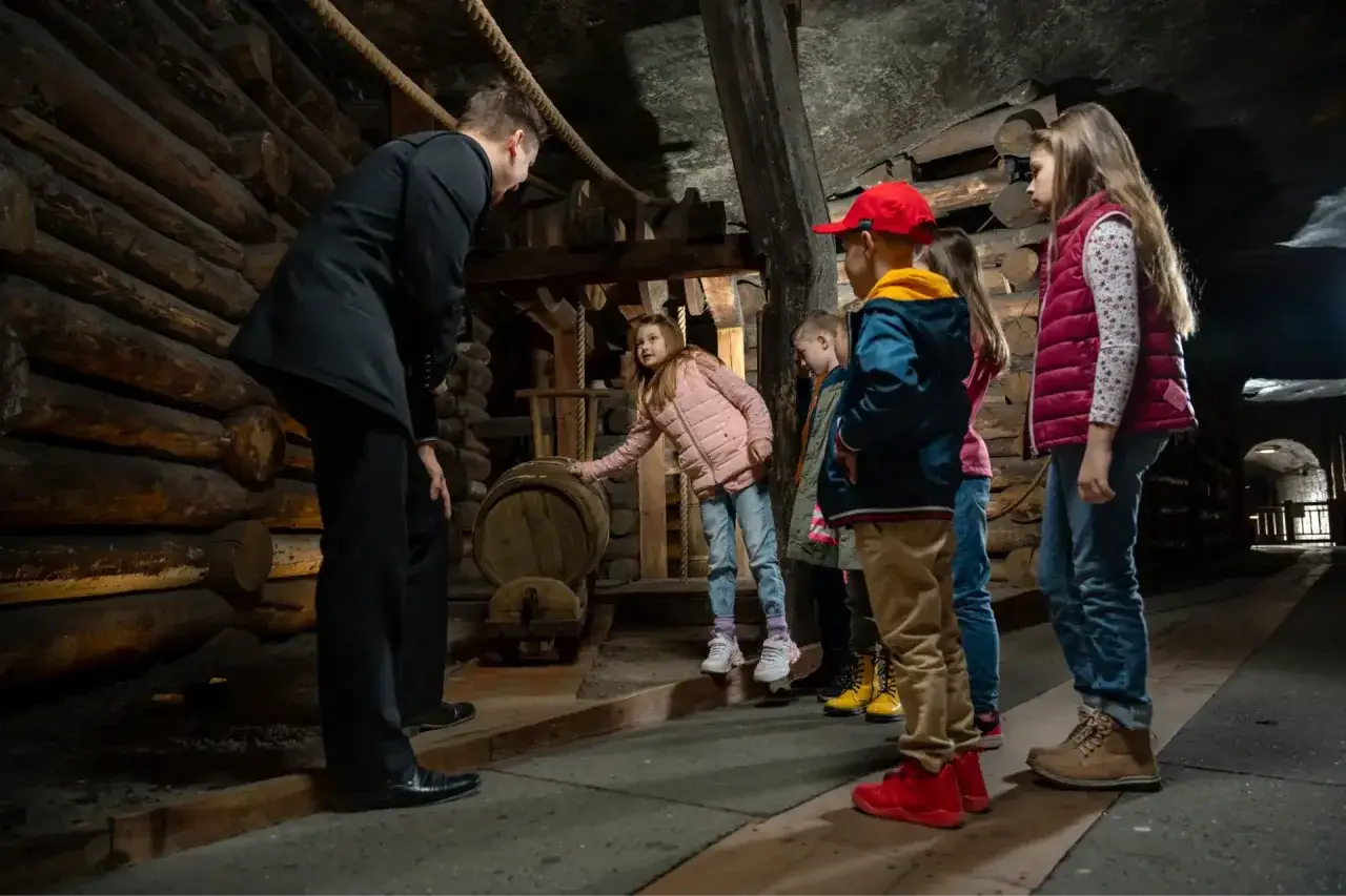 Przewodnik pokazuje dzieciom zabytkowe beczki. To świetne atrakcje dla dzieci pod dachem w województwie pomorskim, gdzie można poznać historię.
