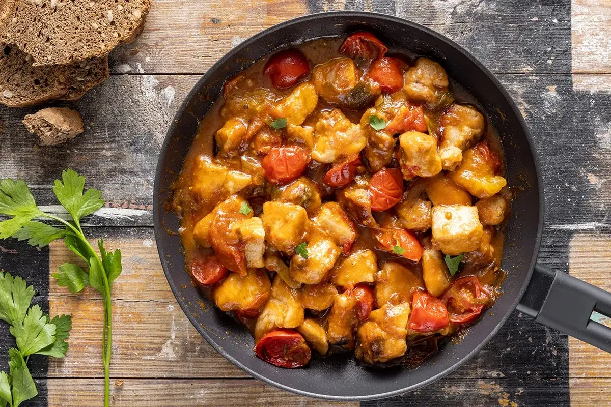 Pezzi di petto di pollo succulento in padella con pomodorini e salsa speziata, un modo diverso per preparare il petto di pollo.