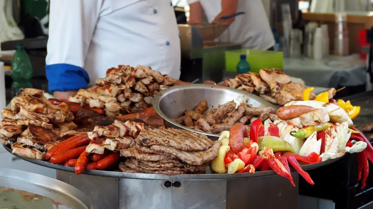 Stor bricka med grillad mat: cevapcici, korvar, kyckling och gr&ouml;nsaker. Perfekt f&ouml;r ett cevapcici recept!