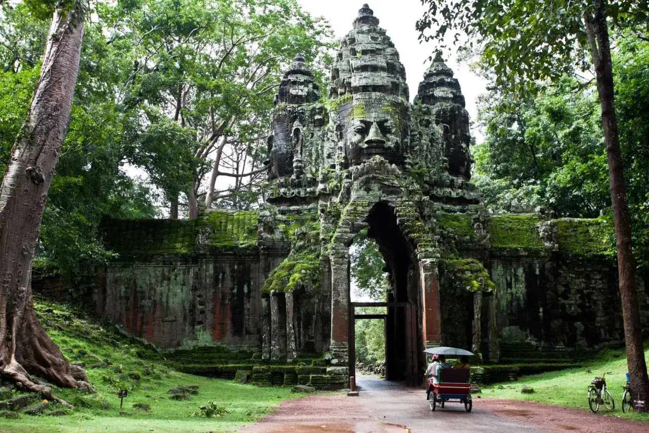 Brama w Angkor Thom, Kambodża. Wspaniałe kamienne twarze witają turystów podczas kambodżańskich wakacji.