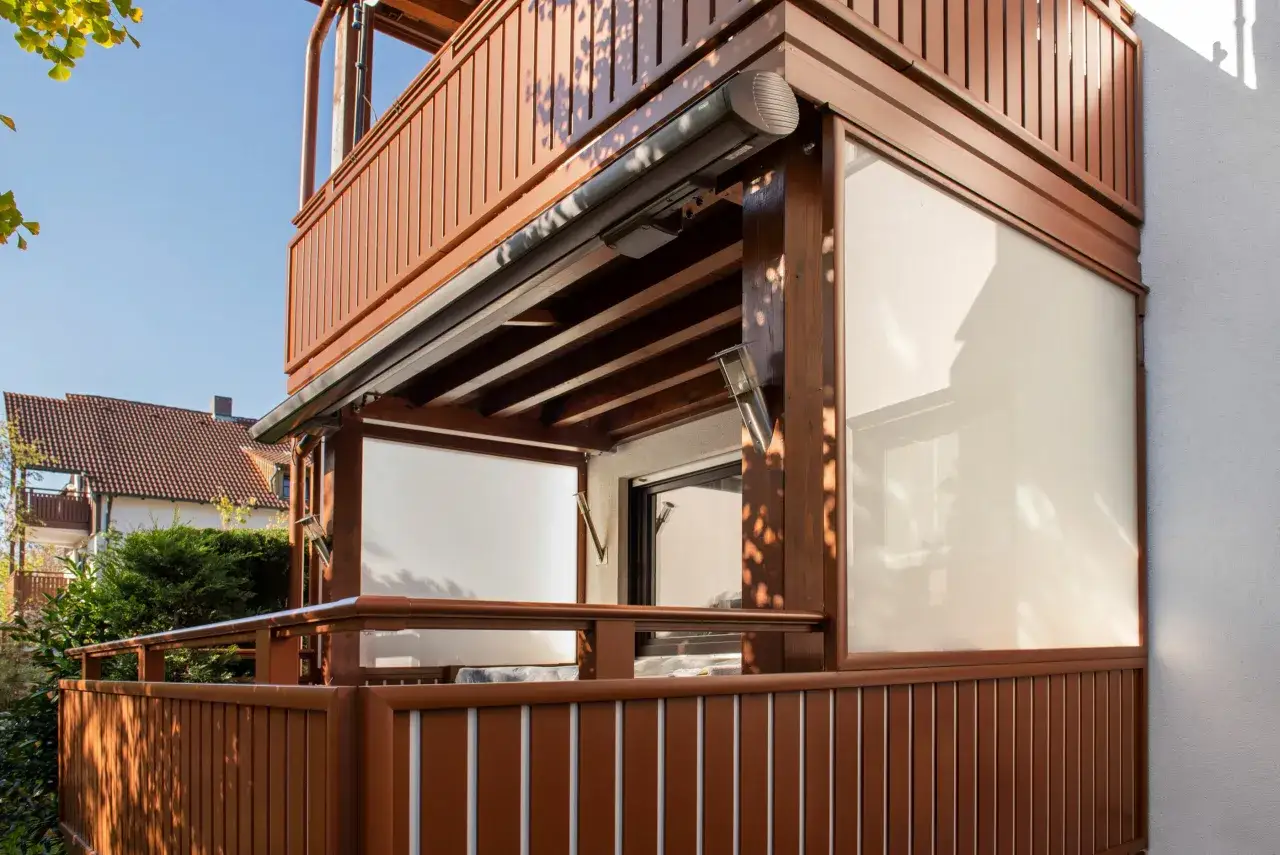 Balcone in legno con pannelli opachi per idee privacy condominio. Ombreggiato da alberi, offre un rifugio sereno.